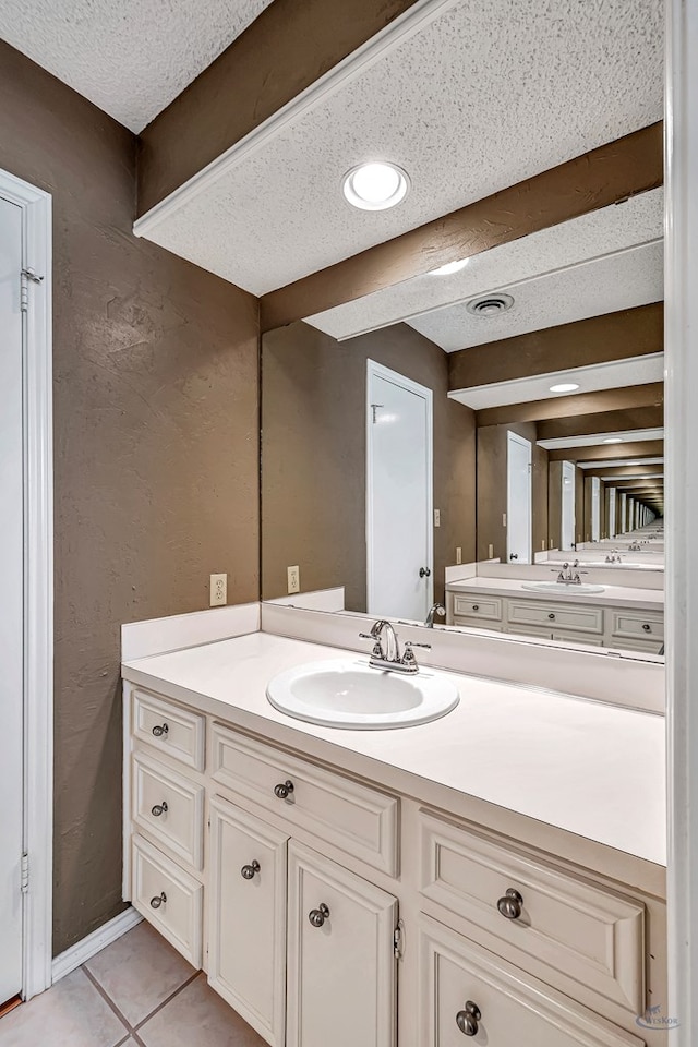 bathroom featuring tile patterned flooring, vanity, and a textured ceiling