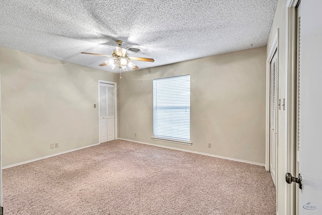 unfurnished bedroom featuring ceiling fan, carpet floors, and a textured ceiling