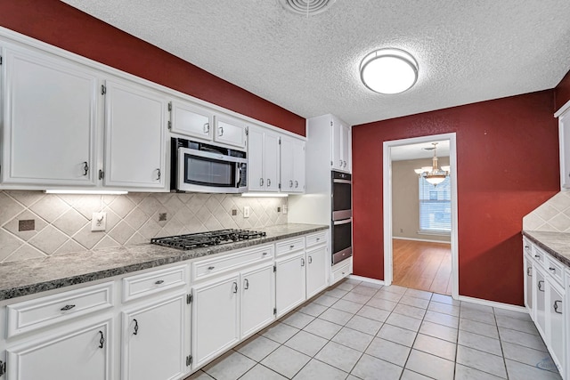 kitchen with white cabinetry, pendant lighting, appliances with stainless steel finishes, and backsplash