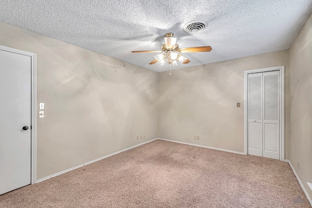 empty room featuring carpet floors, a textured ceiling, and ceiling fan