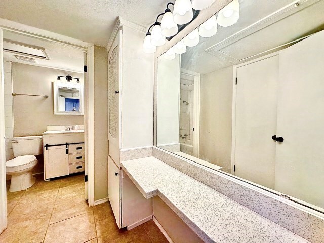 501 W Scharbauer Dr Unit 28, Midland, TX 79705 - bathroom with toilet, a textured ceiling, tile patterned flooring, and vanity