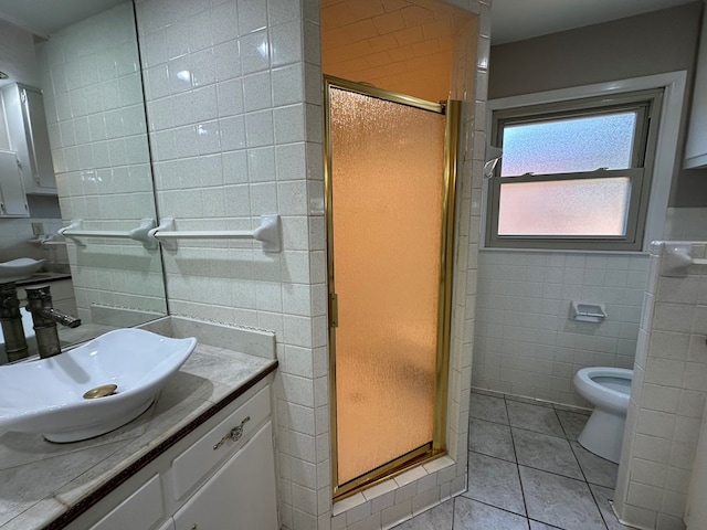 full bath with a stall shower, tile patterned flooring, tile walls, and vanity