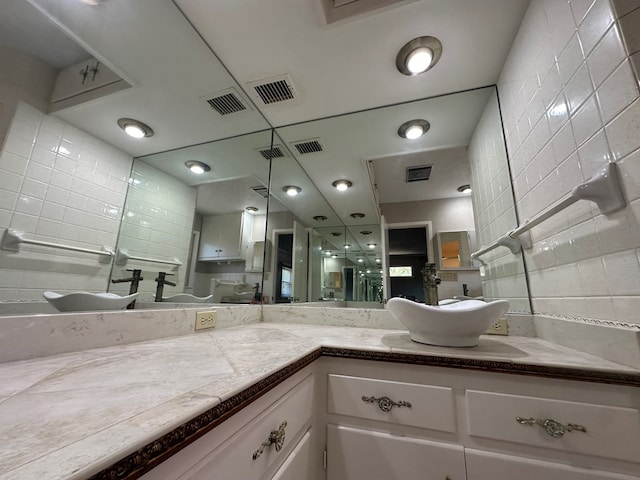 bathroom featuring tile walls, visible vents, and vanity