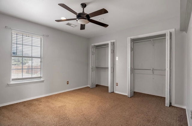 105 Maple Ave, Coahoma, TX 79720 - unfurnished bedroom featuring two closets, carpet flooring, baseboards, and a ceiling fan