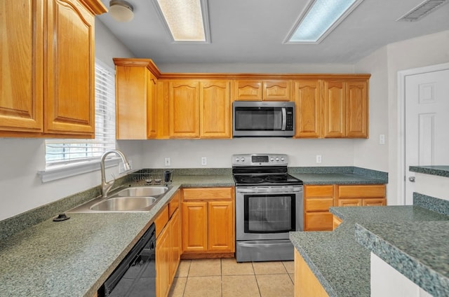 105 Maple Ave, Coahoma, TX 79720 - kitchen featuring stainless steel appliances, a sink, light tile patterned floors, and dark countertops