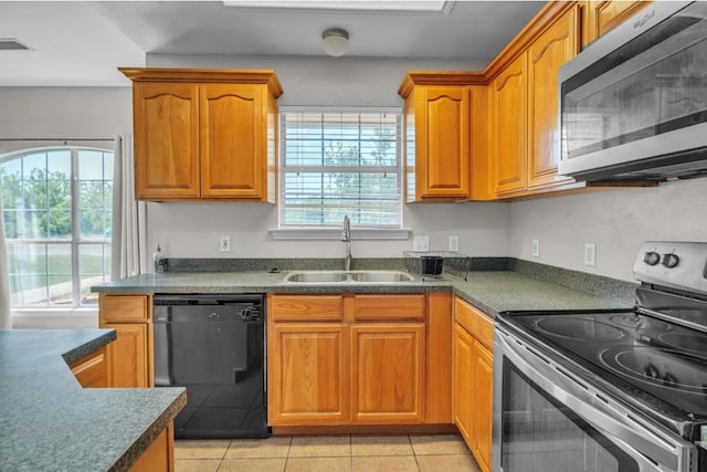 105 Maple Ave, Coahoma, TX 79720 - kitchen featuring stainless steel appliances, a sink, dark countertops, and brown cabinets