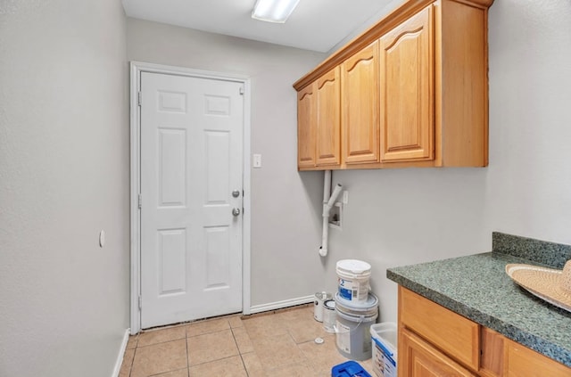 105 Maple Ave, Coahoma, TX 79720 - washroom with light tile patterned floors, cabinet space, and baseboards