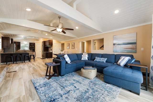 living room featuring light wood-type flooring, vaulted ceiling with beams, and ceiling fan