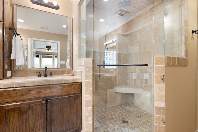 bathroom featuring ceiling fan, walk in shower, and vanity