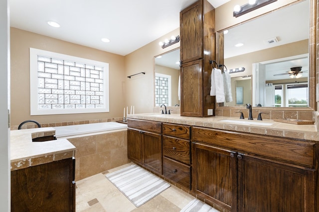 bathroom with ceiling fan, tile patterned flooring, vanity, and a relaxing tiled tub