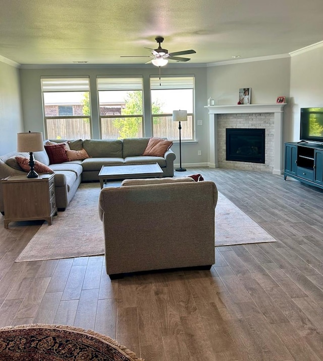 7103 Mcpherson Ln, Midland, TX 79706 - living room with crown molding, wood finished floors, ceiling fan, and a fireplace