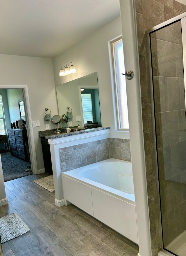 7103 Mcpherson Ln, Midland, TX 79706 - ensuite bathroom featuring a bath, a shower stall, wood finished floors, and vanity