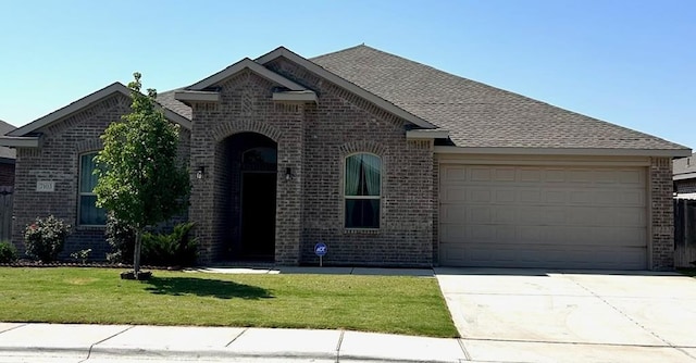 7103 Mcpherson Ln, Midland, TX 79706 - french country inspired facade with brick siding, a garage, concrete driveway, and a front yard