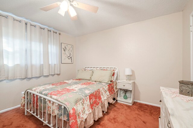 carpeted bedroom with ceiling fan and a textured ceiling