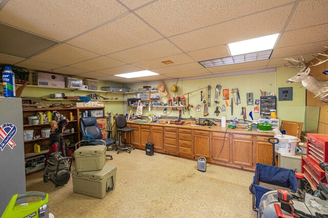 miscellaneous room featuring a drop ceiling and a workshop area