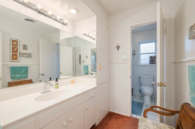 bathroom with vanity, toilet, and tile patterned flooring