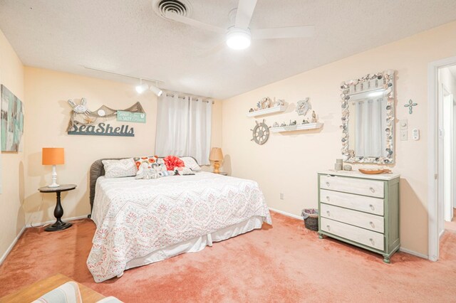 carpeted bedroom featuring ceiling fan and a textured ceiling