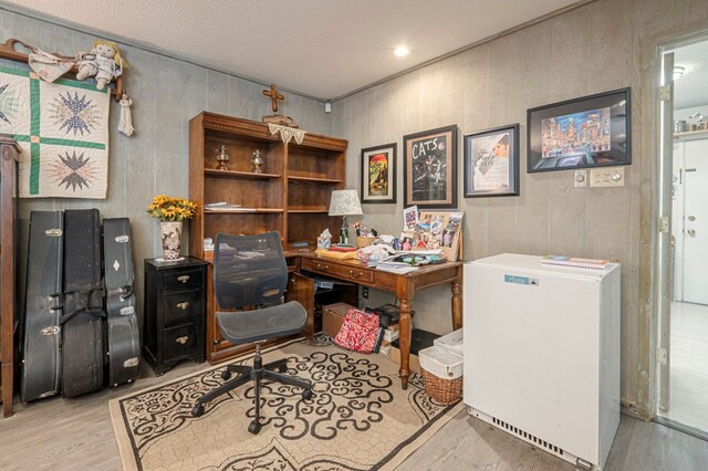 home office featuring a textured ceiling and light hardwood / wood-style flooring