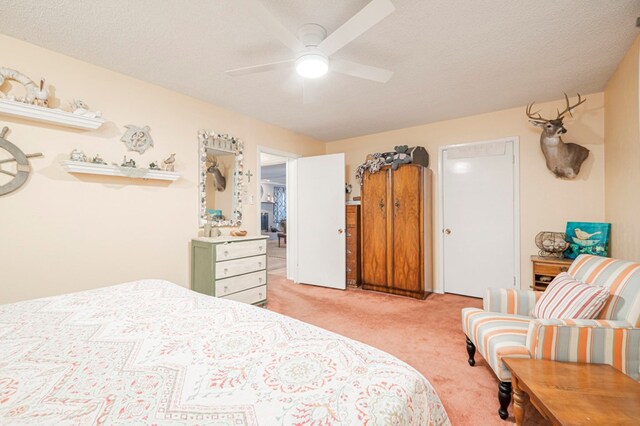 bedroom featuring ceiling fan, light colored carpet, and a textured ceiling