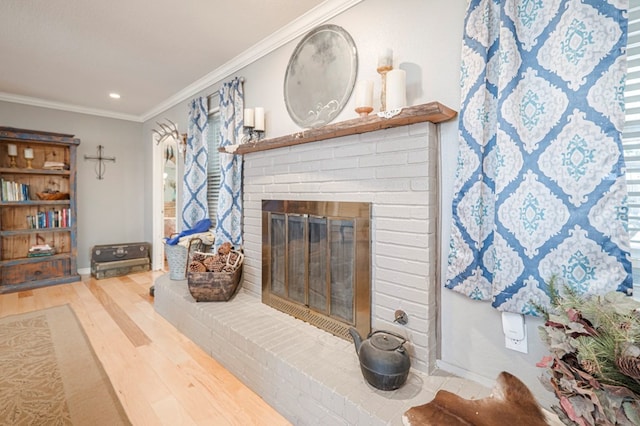 living room with wood-type flooring, a brick fireplace, and ornamental molding