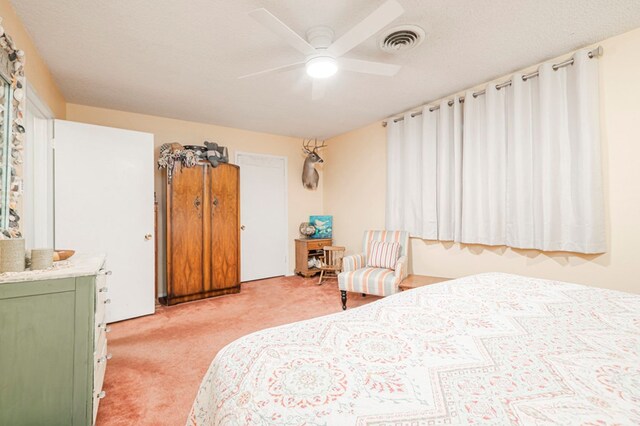 carpeted bedroom with a textured ceiling and ceiling fan