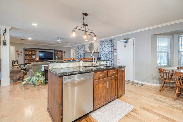 kitchen with dishwasher, hanging light fixtures, sink, an island with sink, and dark stone counters