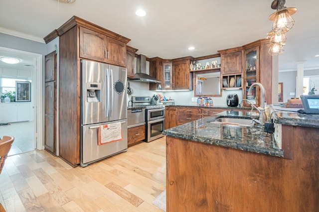 kitchen featuring dark stone counters, sink, pendant lighting, stainless steel appliances, and wall chimney exhaust hood