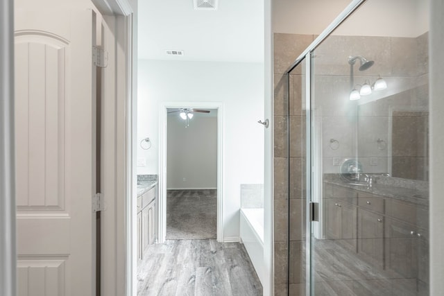 7318 Cross B Rd, Odessa, TX 79765 - bathroom with vanity, wood finished floors, a shower stall, a bath, and a ceiling fan