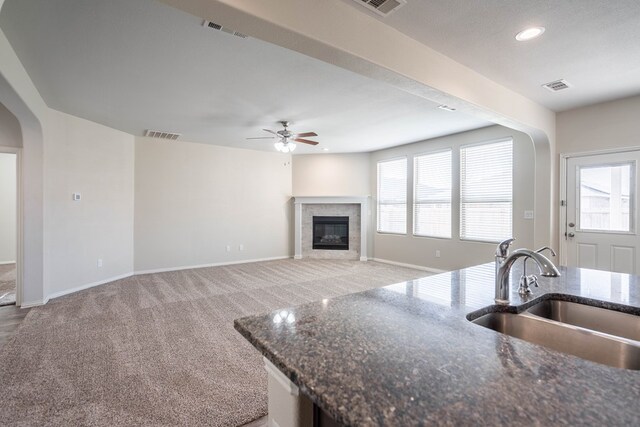 7318 Cross B Rd, Odessa, TX 79765 - kitchen with a ceiling fan, a tiled fireplace, healthy amount of natural light, arched walkways, and recessed lighting