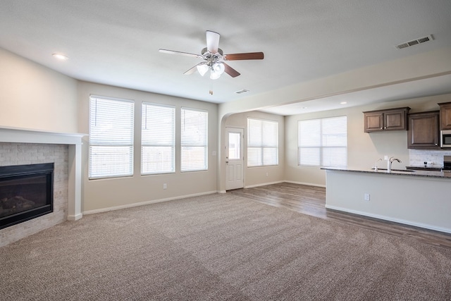 7318 Cross B Rd, Odessa, TX 79765 - unfurnished living room with carpet floors, ceiling fan, a brick fireplace, and recessed lighting