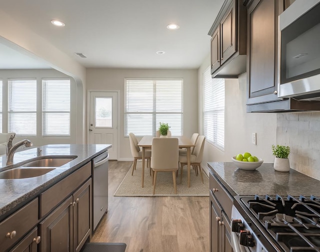 7318 Cross B Rd, Odessa, TX 79765 - kitchen featuring stainless steel appliances, light wood finished floors, recessed lighting, backsplash, and dark stone countertops