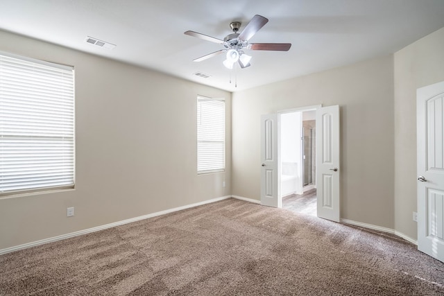 7318 Cross B Rd, Odessa, TX 79765 - unfurnished bedroom featuring light colored carpet, multiple windows, and ensuite bathroom