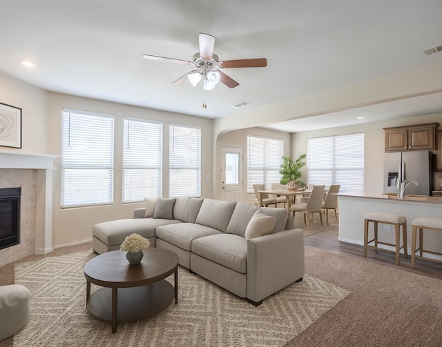 7318 Cross B Rd, Odessa, TX 79765 - carpeted living area featuring ceiling fan, a tiled fireplace, and recessed lighting