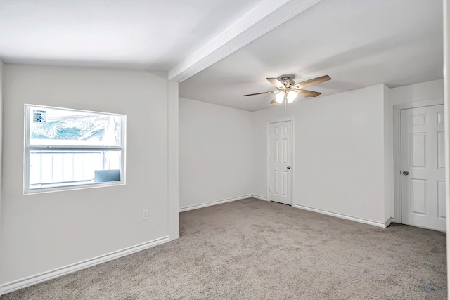 unfurnished room with lofted ceiling with beams, ceiling fan, and light colored carpet