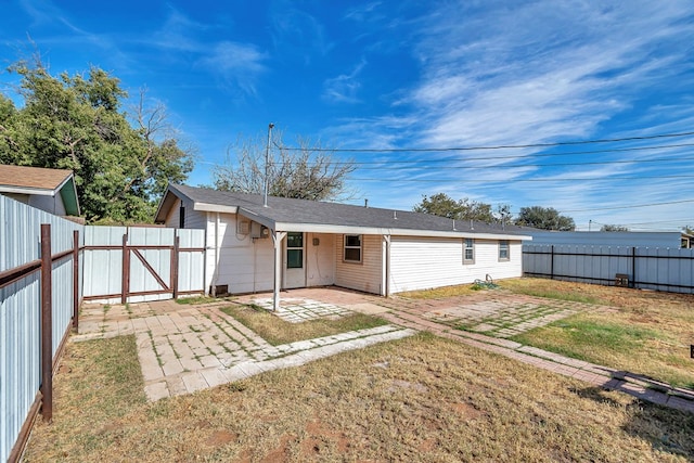 back of property featuring a patio area and a lawn