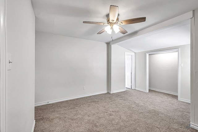 spare room featuring ceiling fan, carpet floors, and vaulted ceiling