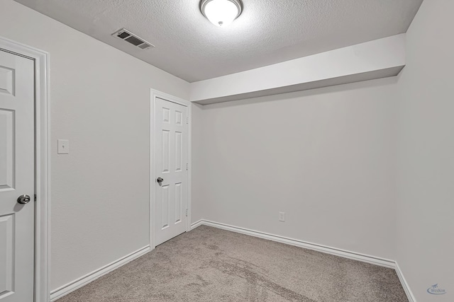 carpeted spare room with a textured ceiling