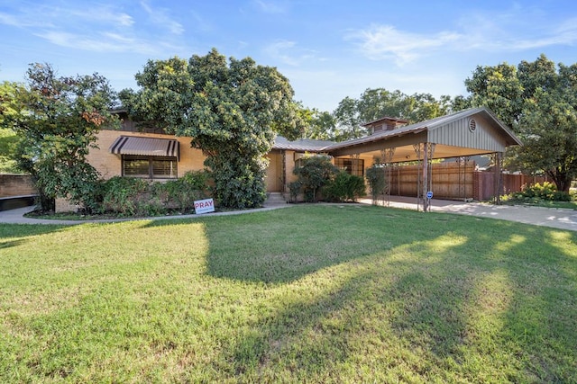 view of front of house featuring fence, a front lawn, concrete driveway, and a carport