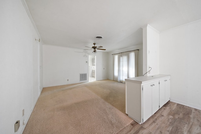 unfurnished living room featuring crown molding, baseboards, visible vents, and a ceiling fan