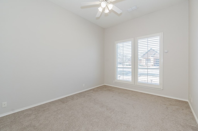 empty room with ceiling fan, vaulted ceiling, and light carpet