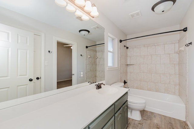 full bathroom with vanity, hardwood / wood-style floors, toilet, and tiled shower / bath