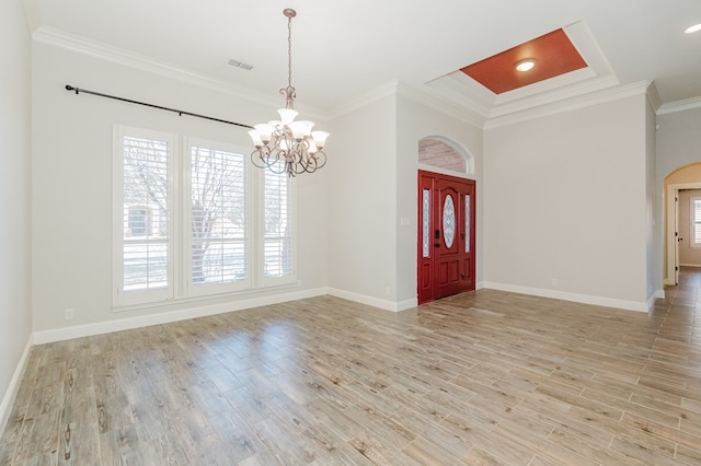 foyer featuring ornamental molding, a chandelier, and light wood-type flooring