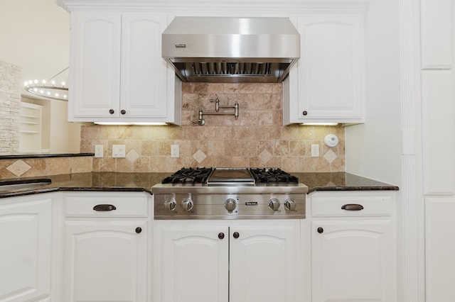 kitchen with tasteful backsplash, extractor fan, white cabinets, dark stone counters, and stainless steel gas stovetop