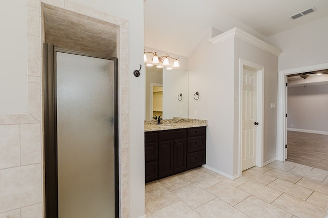 bathroom with tile patterned flooring, vanity, a shower with door, and lofted ceiling