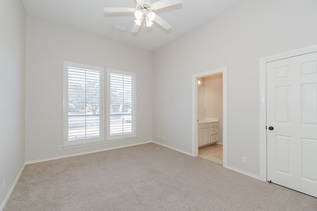 unfurnished bedroom featuring light carpet, ceiling fan, and ensuite bathroom