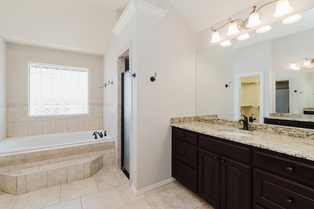 bathroom with vaulted ceiling, tiled bath, tile patterned floors, and vanity