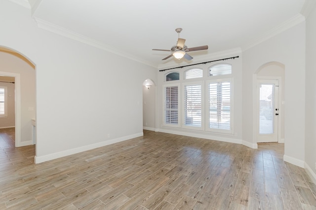 empty room with ornamental molding, a healthy amount of sunlight, and light wood-type flooring