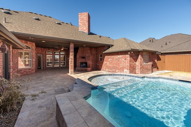 view of swimming pool featuring a fireplace, a patio, and ceiling fan