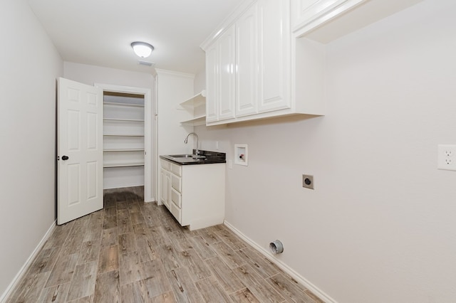 laundry area with sink, cabinets, washer hookup, hookup for an electric dryer, and light wood-type flooring