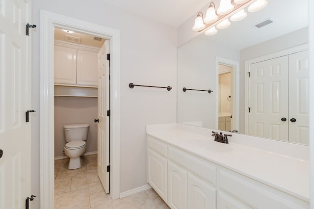 bathroom featuring tile patterned flooring, vanity, toilet, and an inviting chandelier